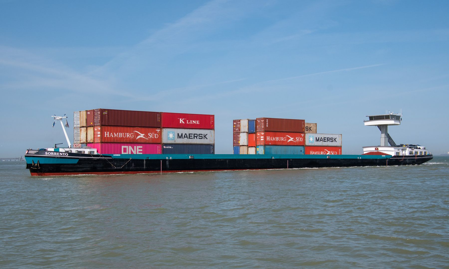 Container vessel crossing blue ocean in daylight